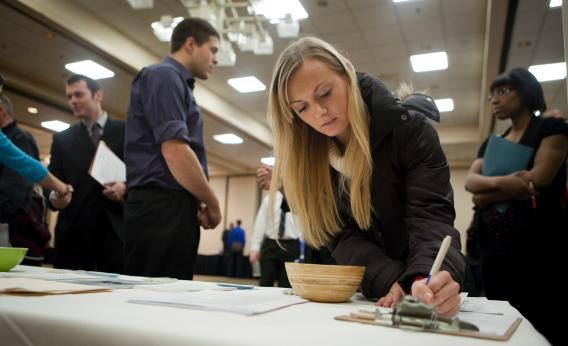 Jenny Pazar, who is currently an intern, fills out a form as she looks for a job at a job fair Dec. 02, 2011, in Portland, Ore.