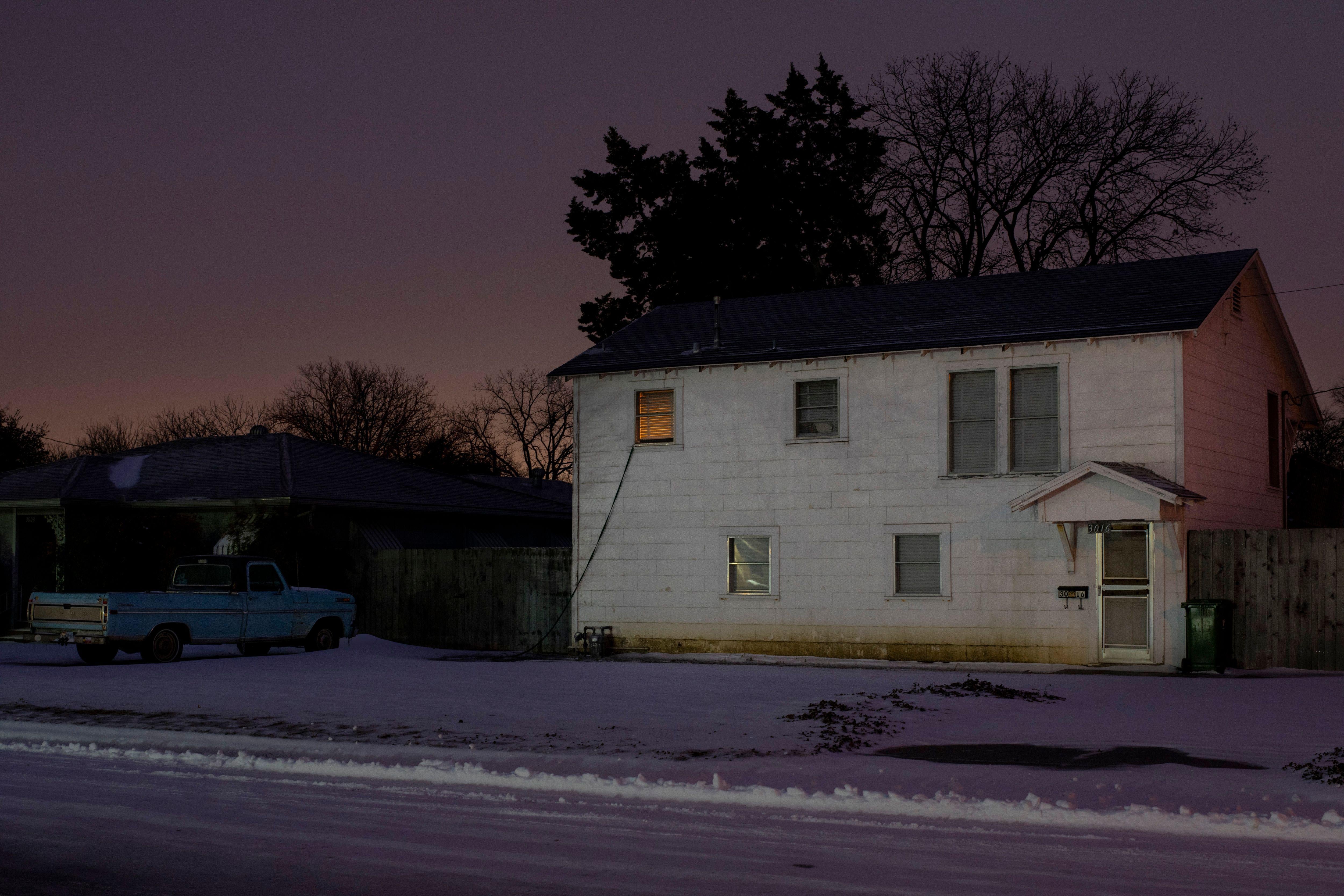 A light is seen from a house in Waco, Texas in the wake of a severe winter storm. 