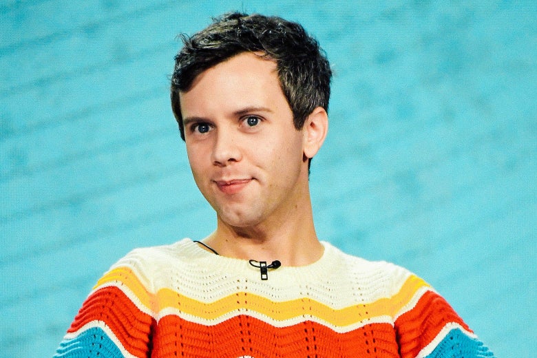 Young white man with short hair wearing a brightly colored sweater.