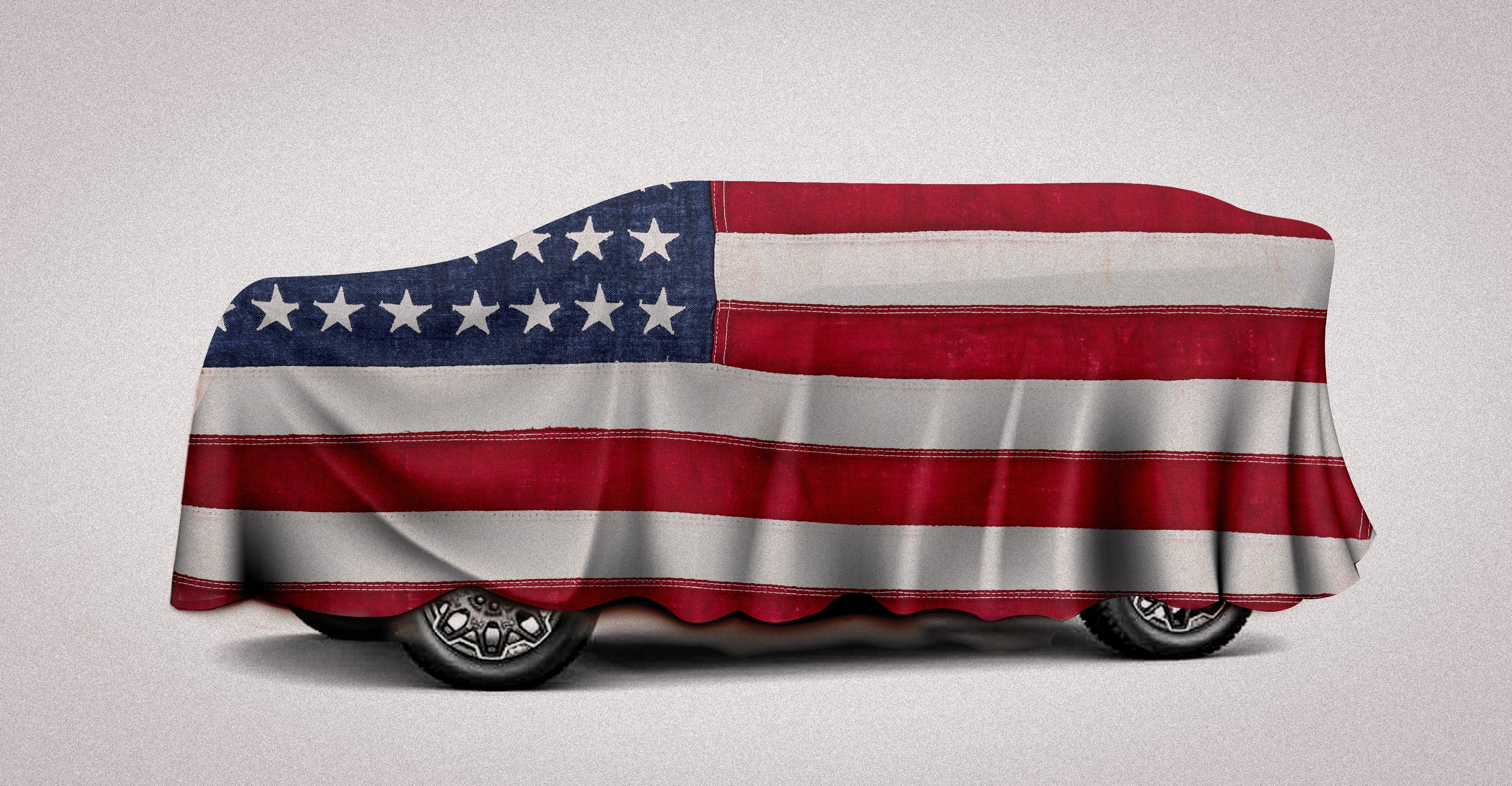 A large car hidden under an American flag.