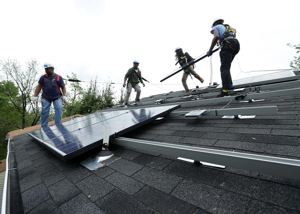 Workers put solar panels down during an installation May 3, 2016 in Washington, DC.