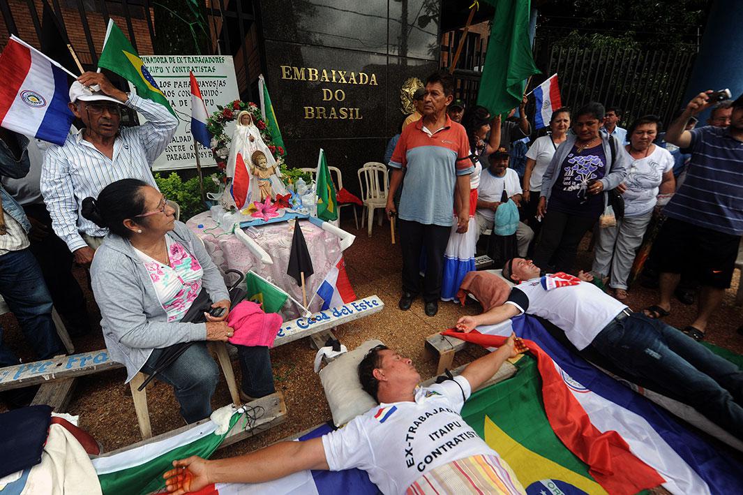 Two former employees of Unicom, contractor of the Itaipu Dam, lie on crosses after being “crucified” by fellow co-workers during a protest in front of he Brazilian embassy in Asunción, Paraguay, on Nov. 12, 2014. They were demanding compensation benefits after the two workers were fired from their jobs. The Itaipu hydroelectric dam, the second-biggest in the world after China's Three Gorges facility, straddles the Brazil-Paraguay border