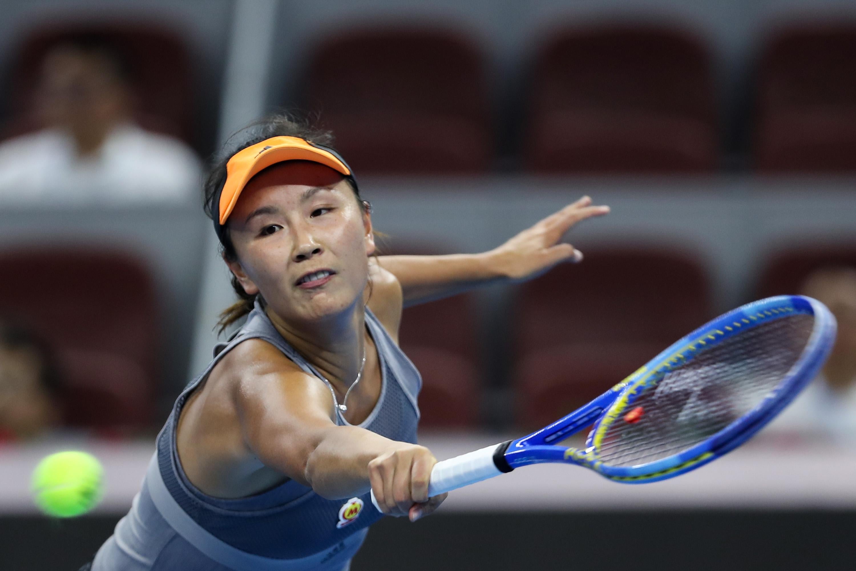 Peng Shuai extends her racket to try to return a shot.