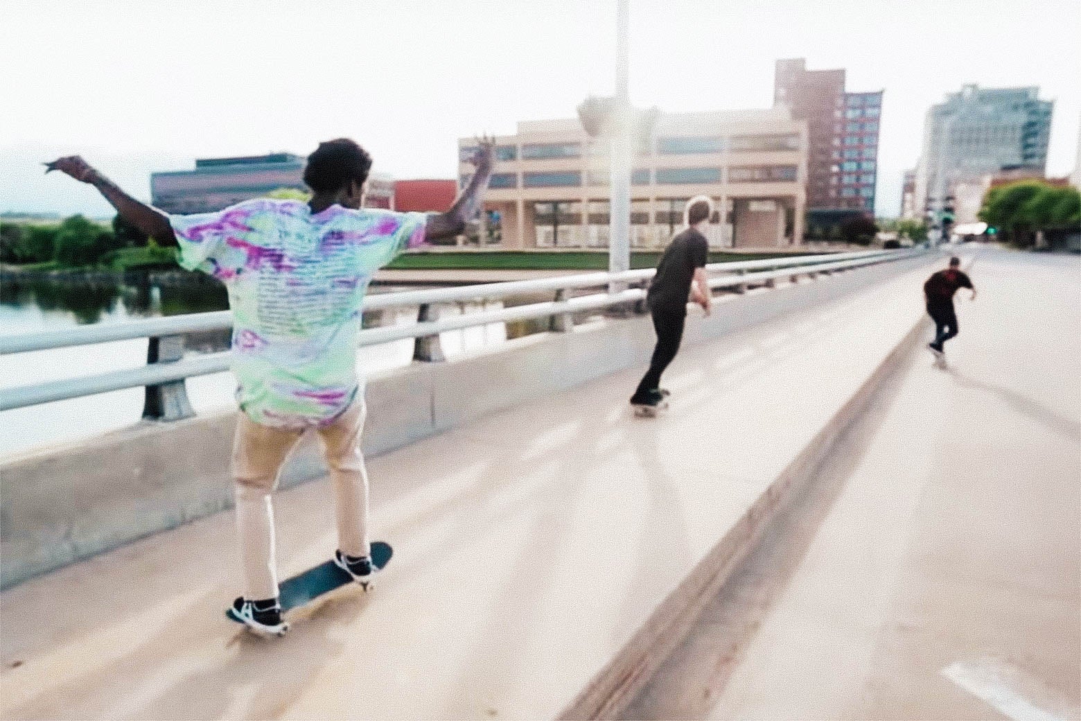 Three skateboarders skate across a bridge, away from the camera, from Minding the Gap.