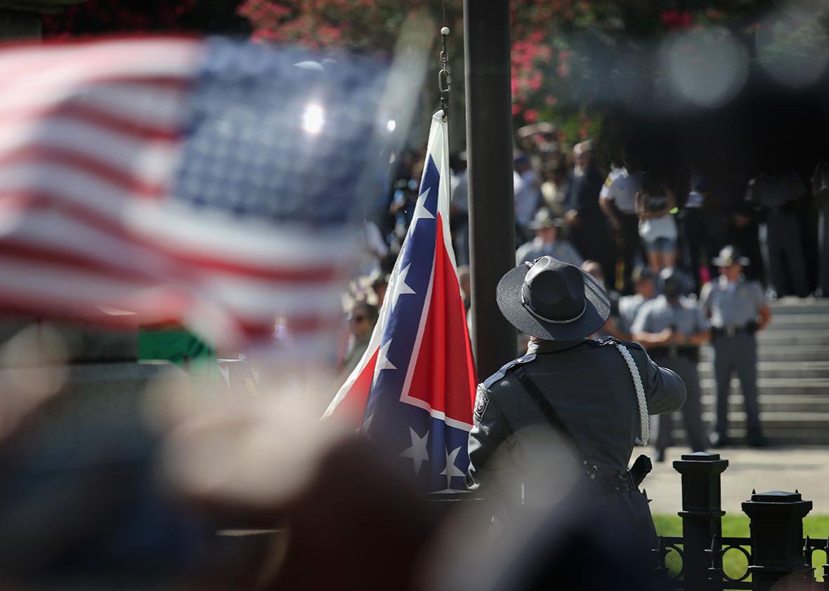 A South Carolina state police honor guard lowers the Confederate