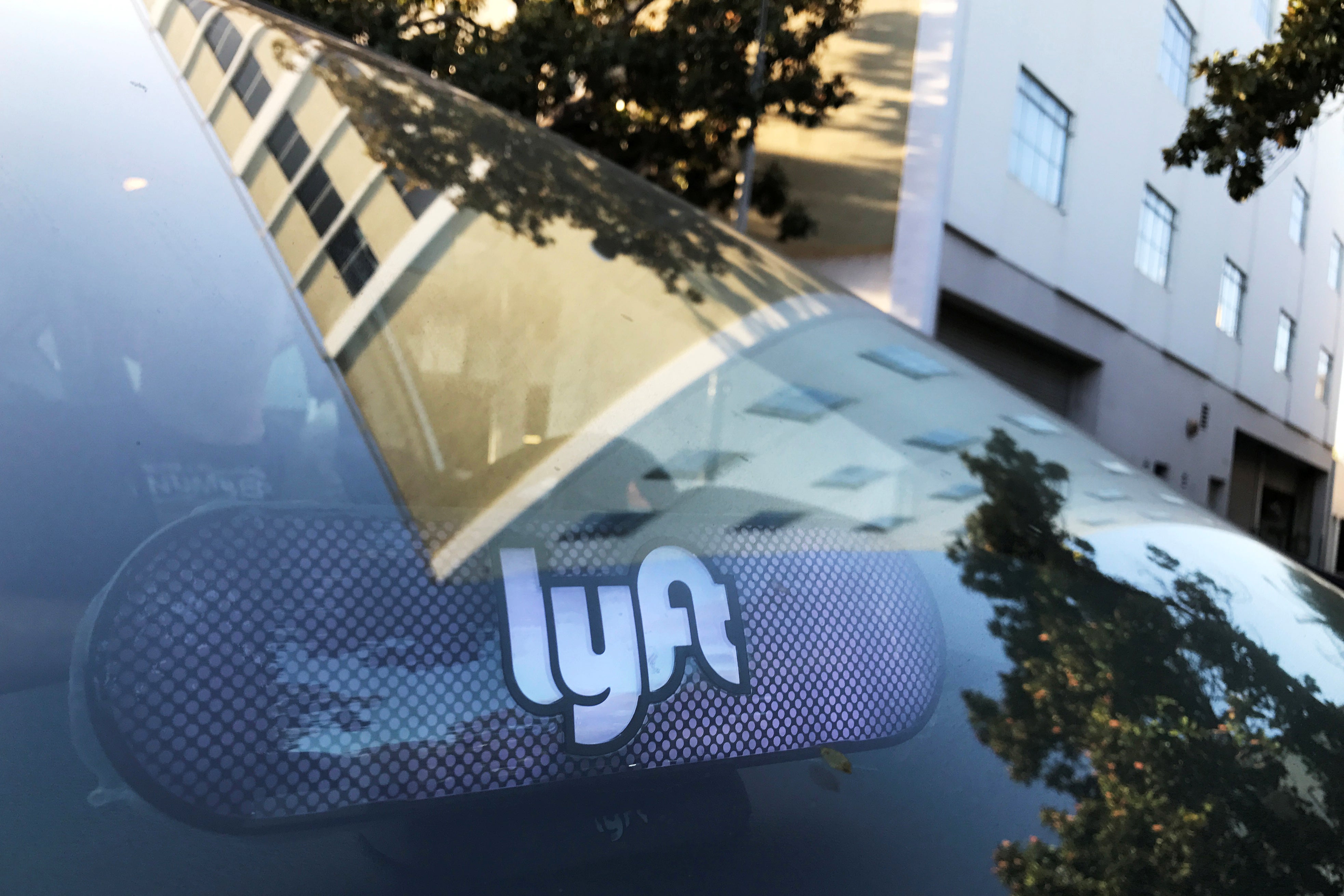 A car with a Lyft sign on the dashboard.