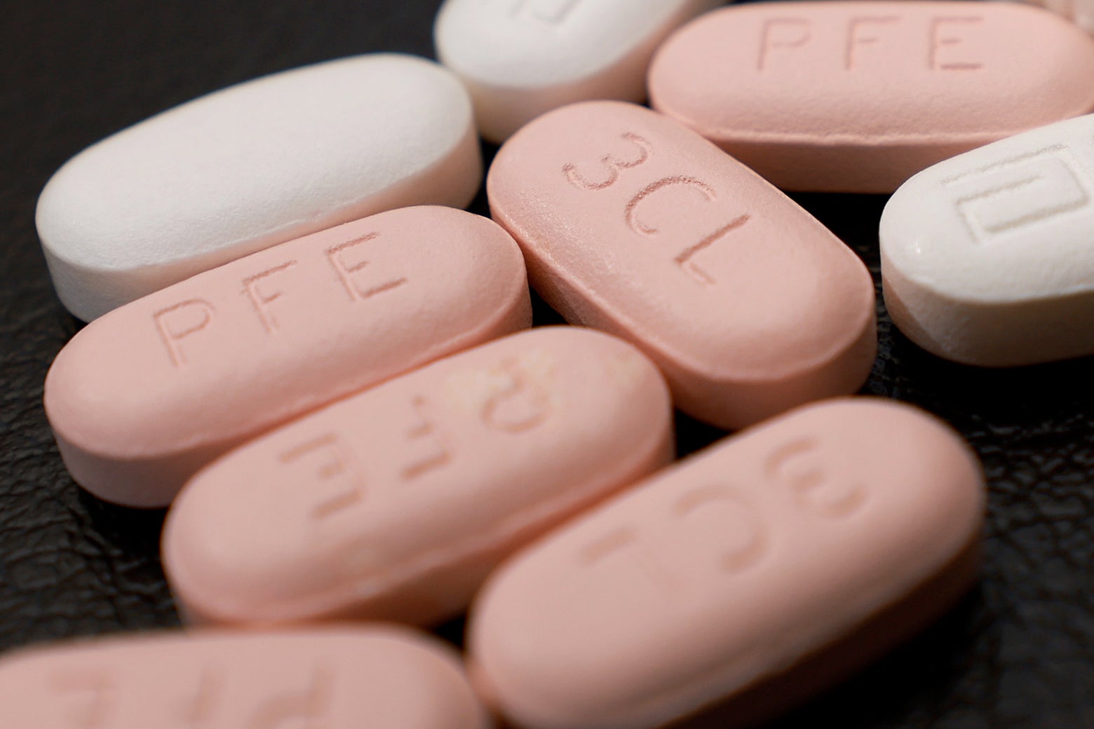 Close up of pink and white Paxlovid pills