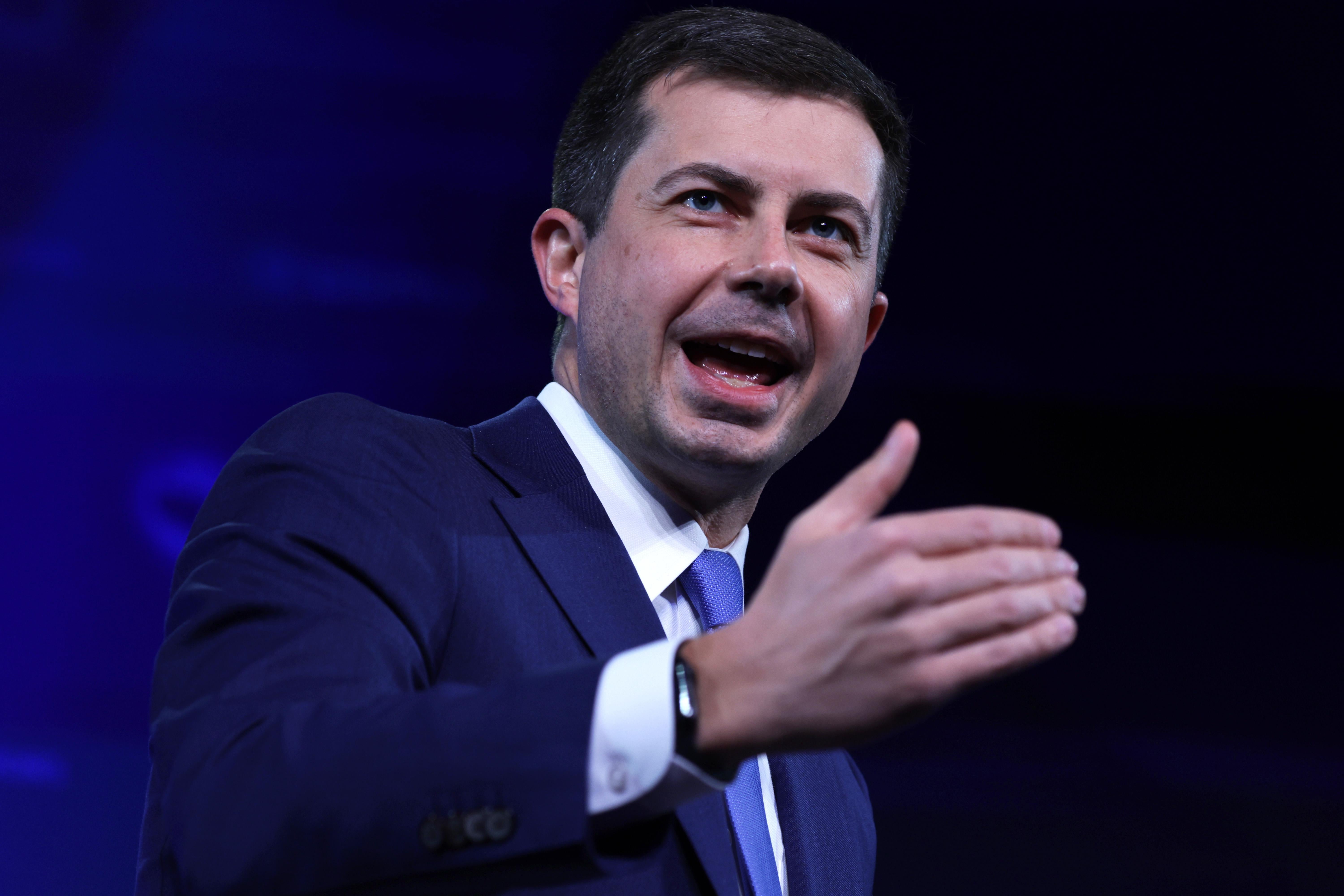 Pete Buttigieg gesturing with one hand as he speaks onstage