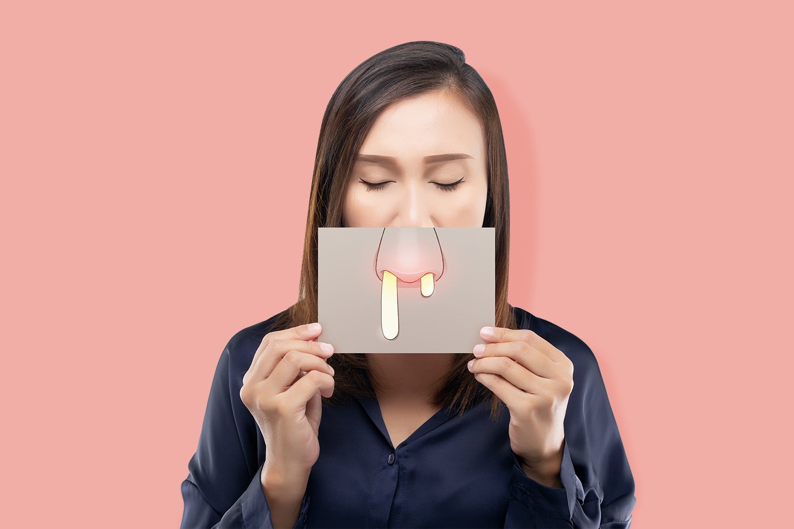 A woman holding over her nose an image of a nose dripping with snot