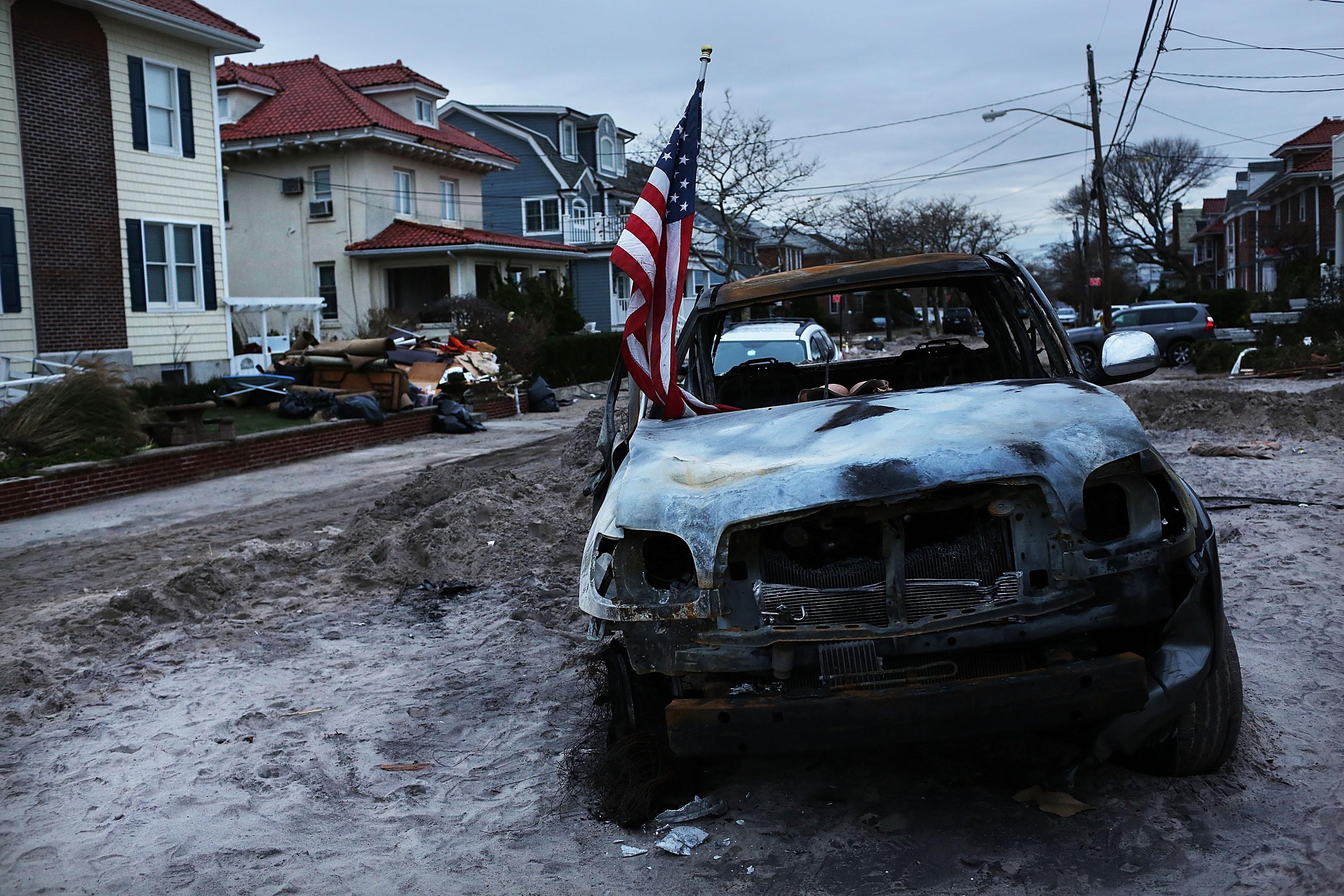 A destroyed car sits in the street in the heavily damaged Rockaway neighborhood, in Queens where a large section of the iconic boardwalk was washed away on November 2, 2012 in New York.