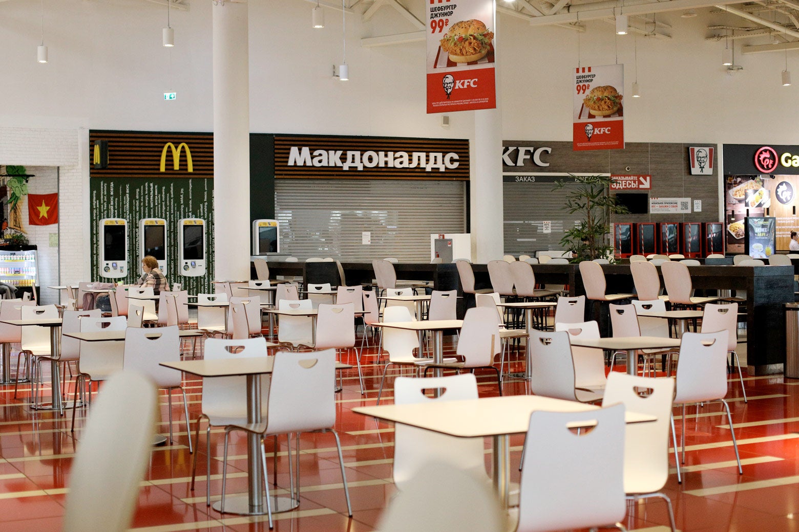 Rows of empty tables and chairs in a food court