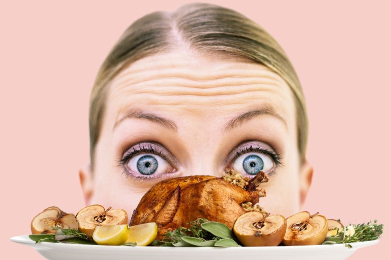 A woman peers at a plate holding a very tiny turkey.
