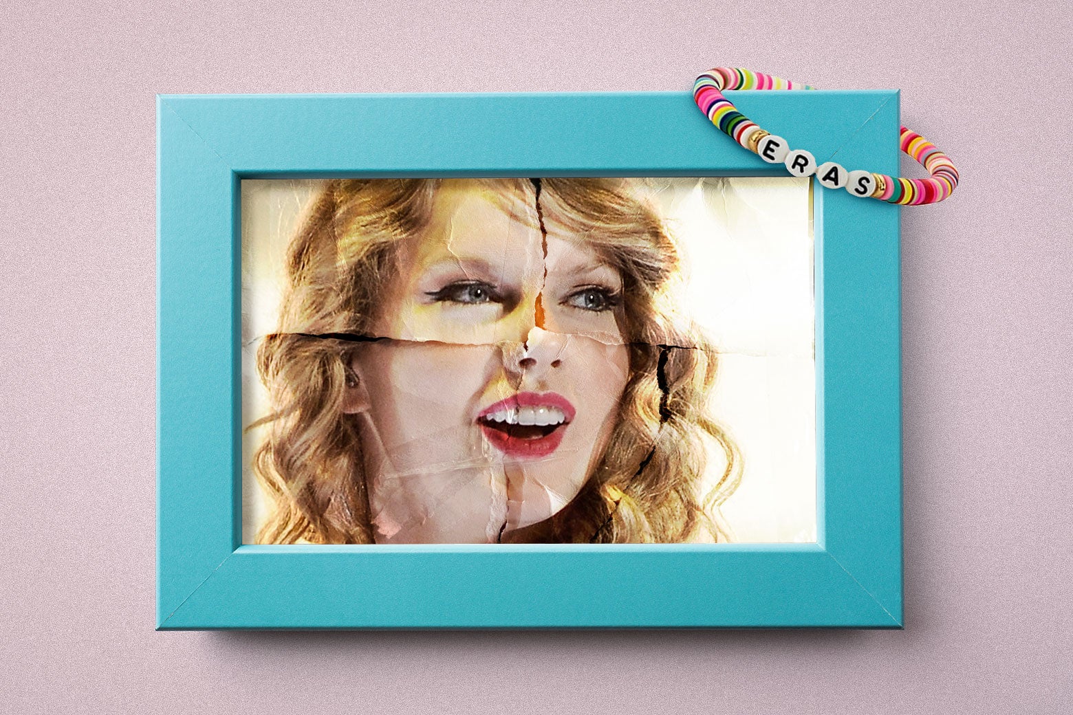 A framed older picture of teenage Taylor Swift, with an "Eras" tour bracelet resting on top.