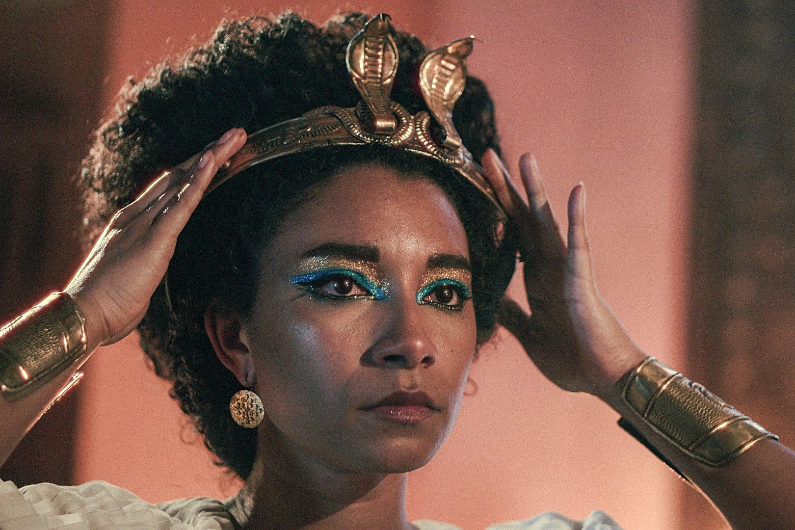 A still from the docuseries shows Adele James in a gold crown and eyeliner as Cleopatra.