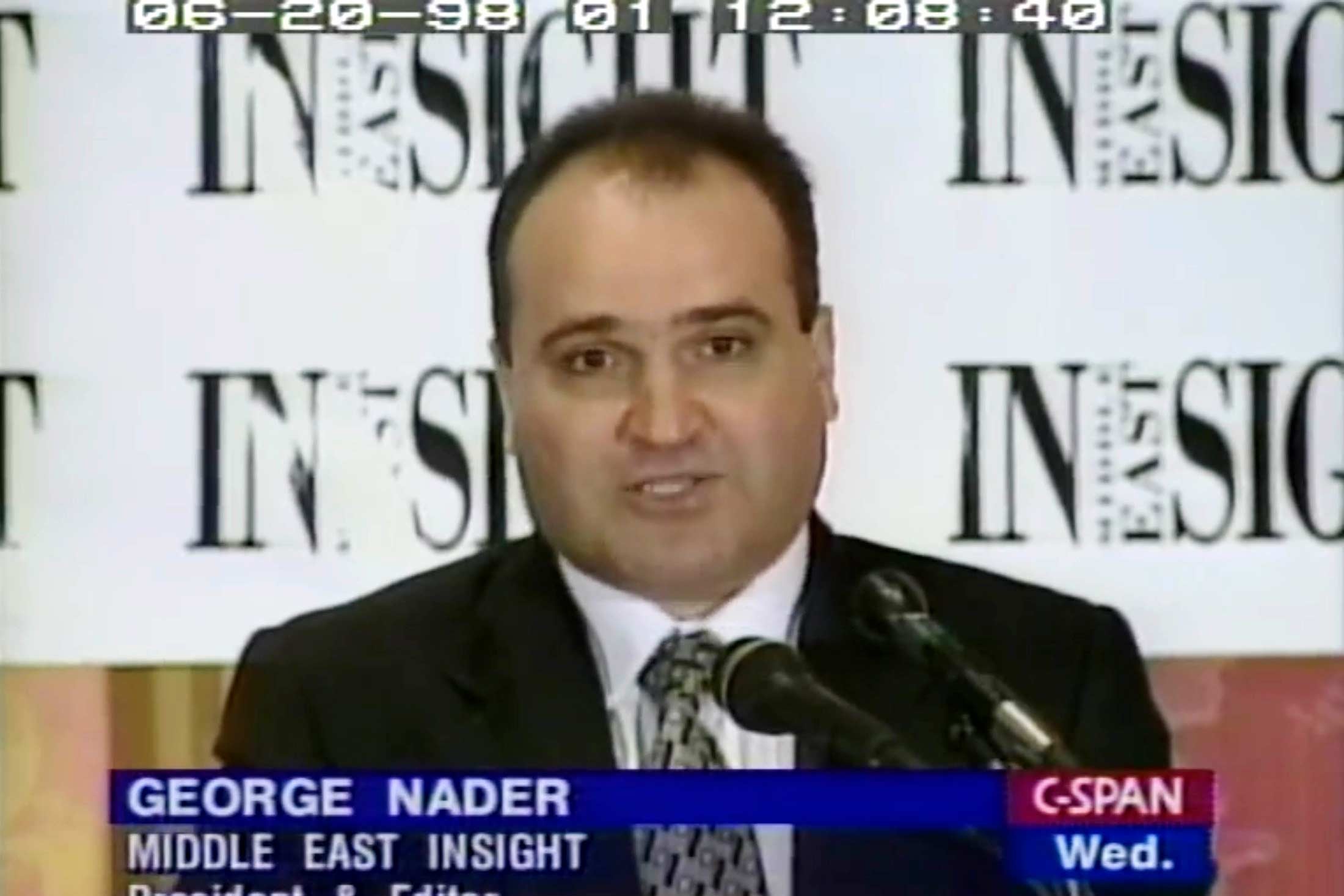 Nader, wearing a suit, speaks at a lectern