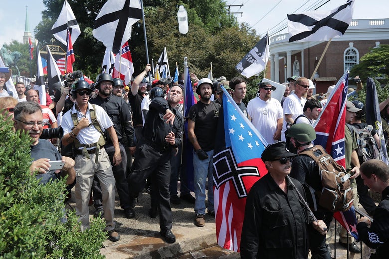 CHARLOTTESVILLE, VA - AUGUST 12: Hundreds of white nationalists, neo-Nazis, KKK and members of the 'alt-right' hurl water bottles back and forth against counter demonstrators on the outskirts of Emancipation Park during the Unite the Right rally August 12, 2017 in Charlottesville, Virginia. After clashes with anti-facist protesters and police the rally was declared an unlawful gathering and people were forced out of Lee Park, where a statue of Confederate General Robert E. Lee is slated to be removed. (Photo by Chip Somodevilla/Getty Images)