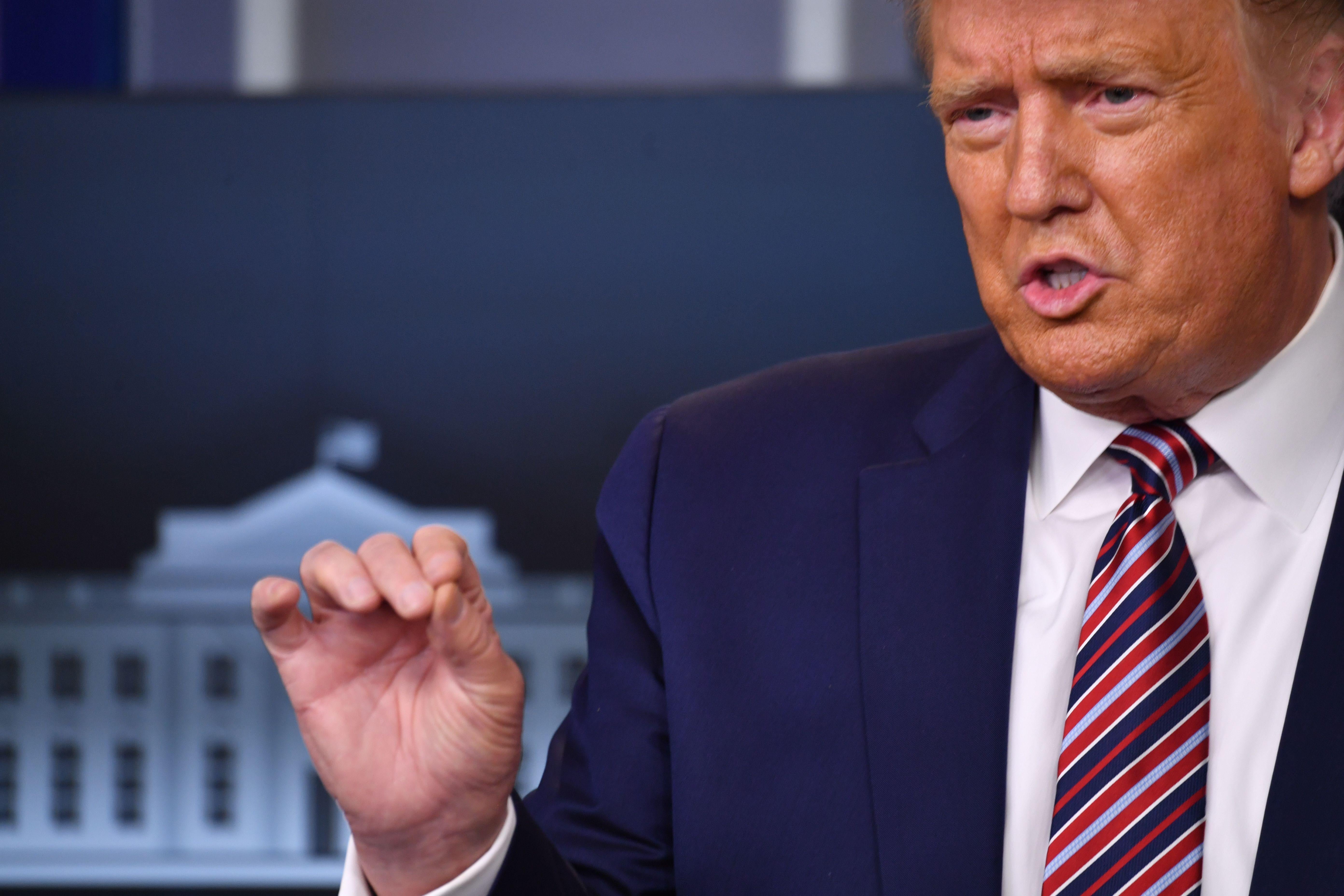 Trump raises his hand and speaks.