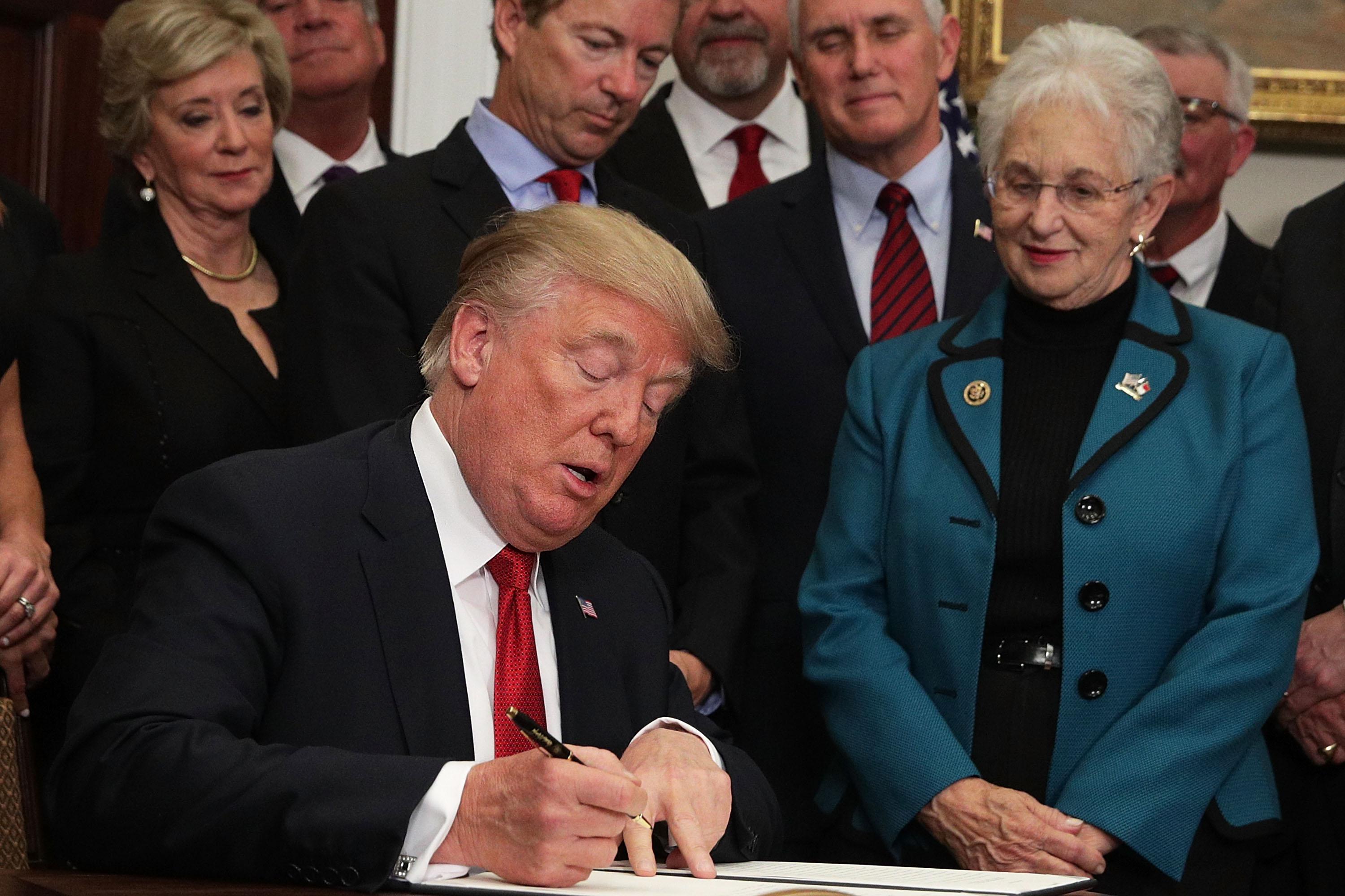 WASHINGTON, DC - OCTOBER 12:  U.S. President Donald Trump signs an executive order as Sen. Rand Paul (R-KY), Vice President Mike Pence, and Rep. Virginia Foxx (R-NC) look on during an event in the Roosevelt Room of the White House October 12, 2017 in Washington, DC. President Trump signed the executive order to loosen restrictions on Affordable Care Act 'to promote healthcare choice and competition.'  (Photo by Alex Wong/Getty Images)