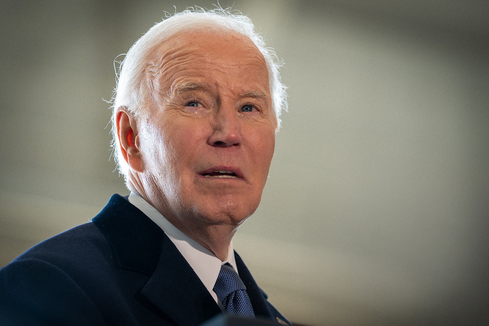 An older white man speaks and scrunches up his forehead.
