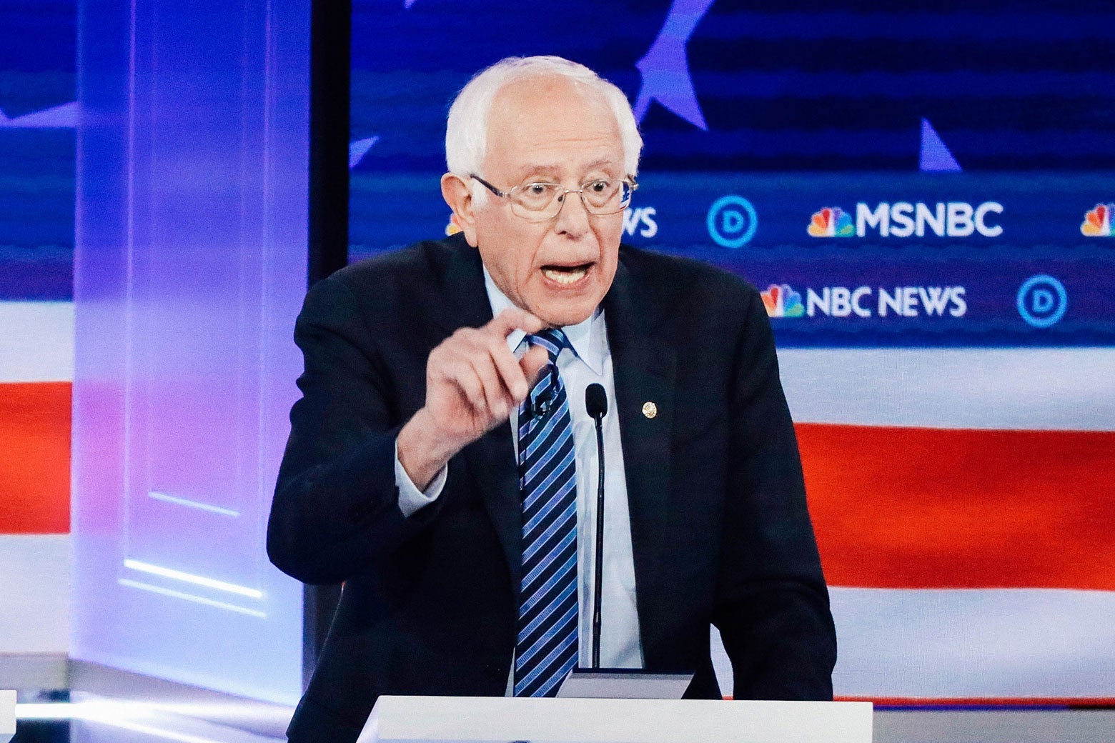 Bernie Sanders gestures while speaking behind a podium at the debate.