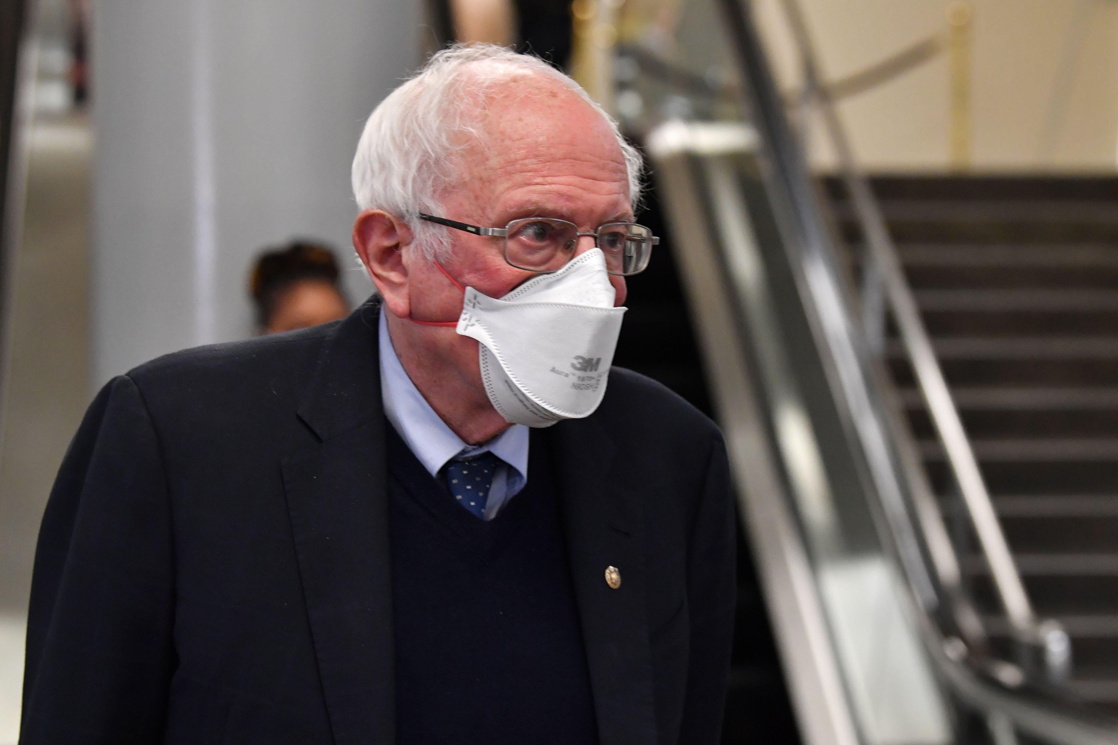 Sanders walks through the halls of Congress with a mask.