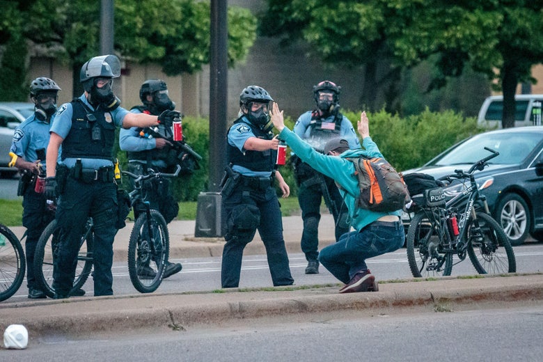 A demonstrator holds up his hands as he is sprayed with pepper spray by two police officers on May 31, 2020 in Minneapolis, Minnesota.