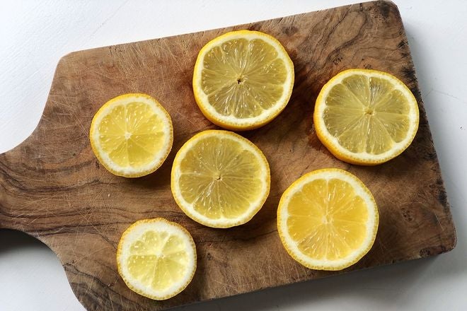 Circular lemon slices arranged on a wooden cutting board