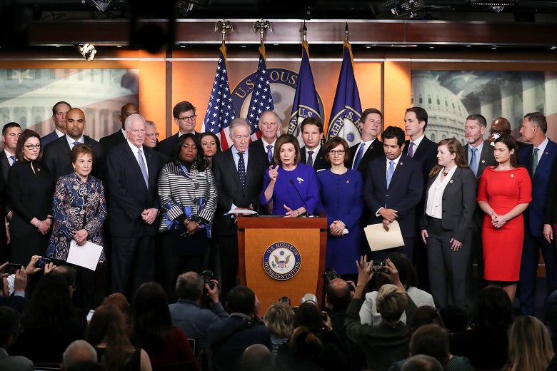 Nancy Pelosi speaking at a podium, flanked by members of Congress. 