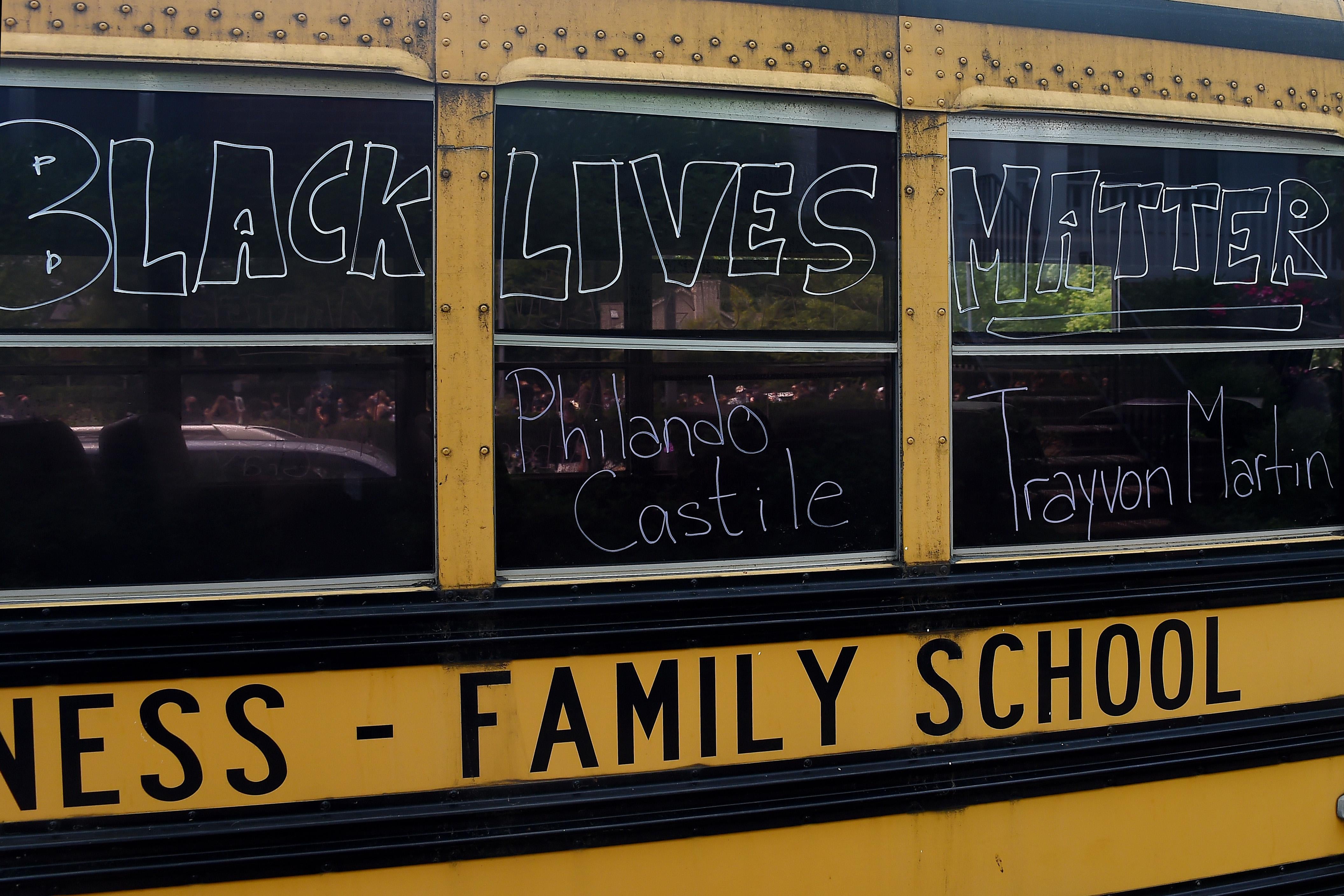 A school bus with Black Lives Matter and the names Trayvon Martin and Philando Castile written on the windows