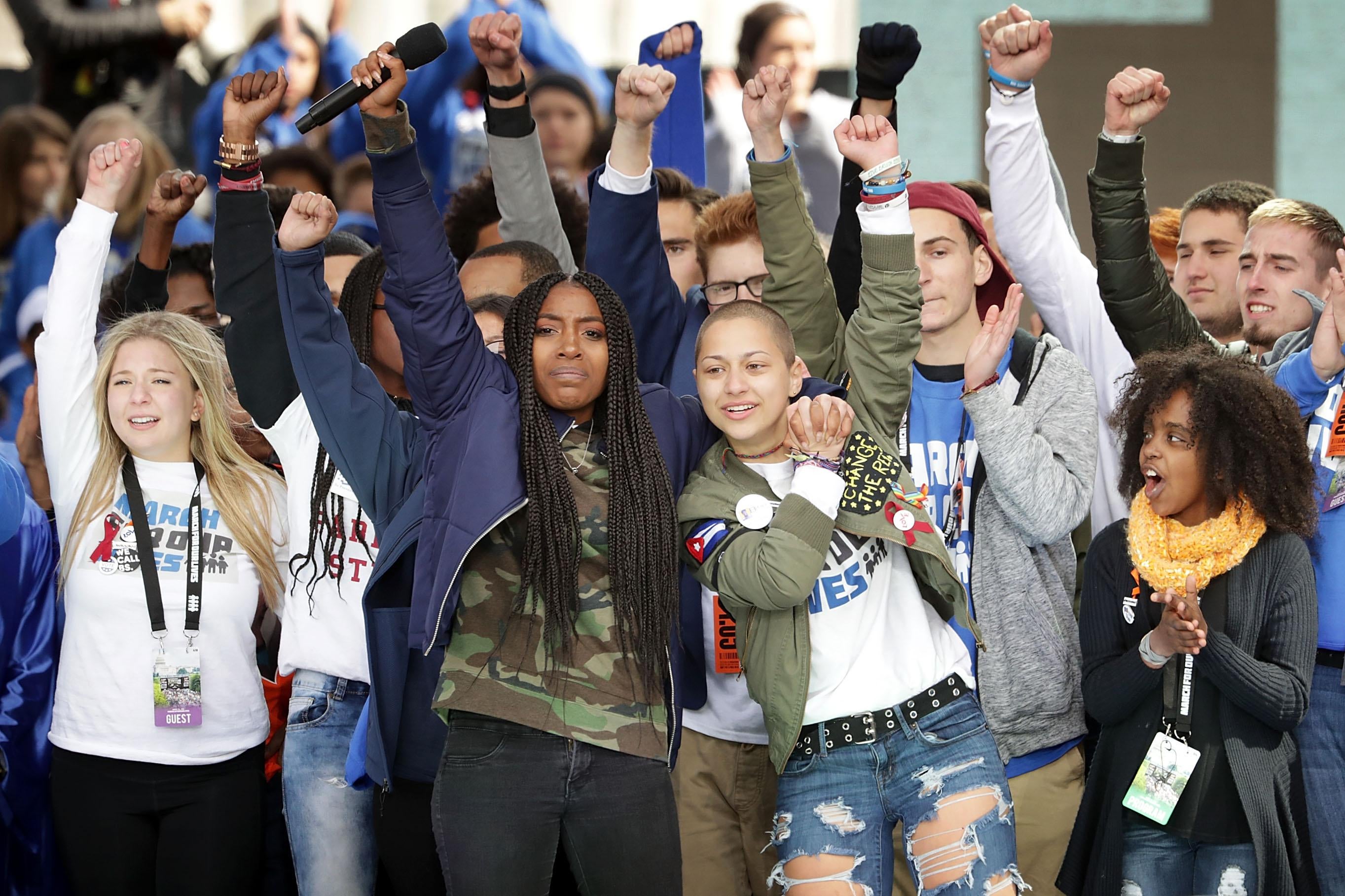WASHINGTON, DC - MARCH 24:  Students from Marjory Stoneman Douglas High School, including Emma Gonzalez (C), stand together on stage with other young victims of gun violence at the conclusion of the March for Our Lives rally on March 24, 2018 in Washington, DC. Hundreds of thousands of demonstrators, including students, teachers and parents gathered in Washington for the anti-gun violence rally organized by survivors of the Marjory Stoneman Douglas High School shooting on February 14 that left 17 dead. More than 800 related events are taking place around the world to call for legislative action to address school safety and gun violence.  (Photo by Chip Somodevilla/Getty Images)