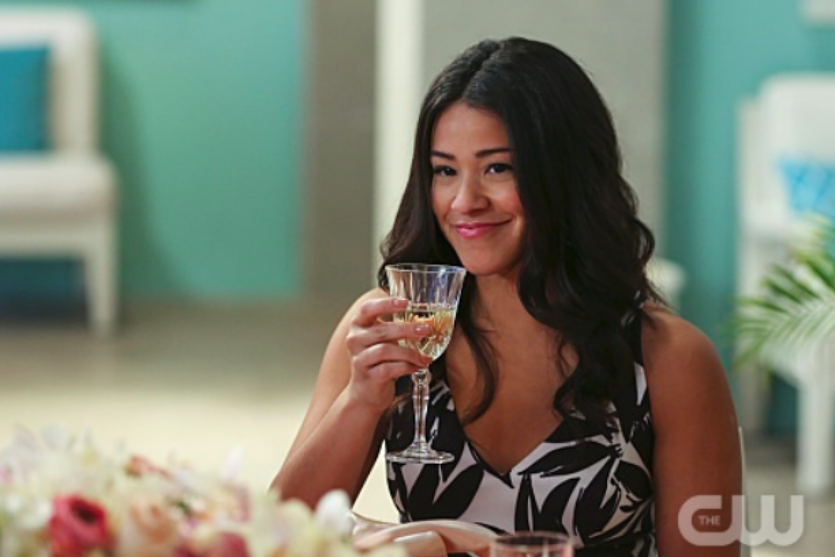 Gina Rodriguez as Jane, smiling and raising a glass.