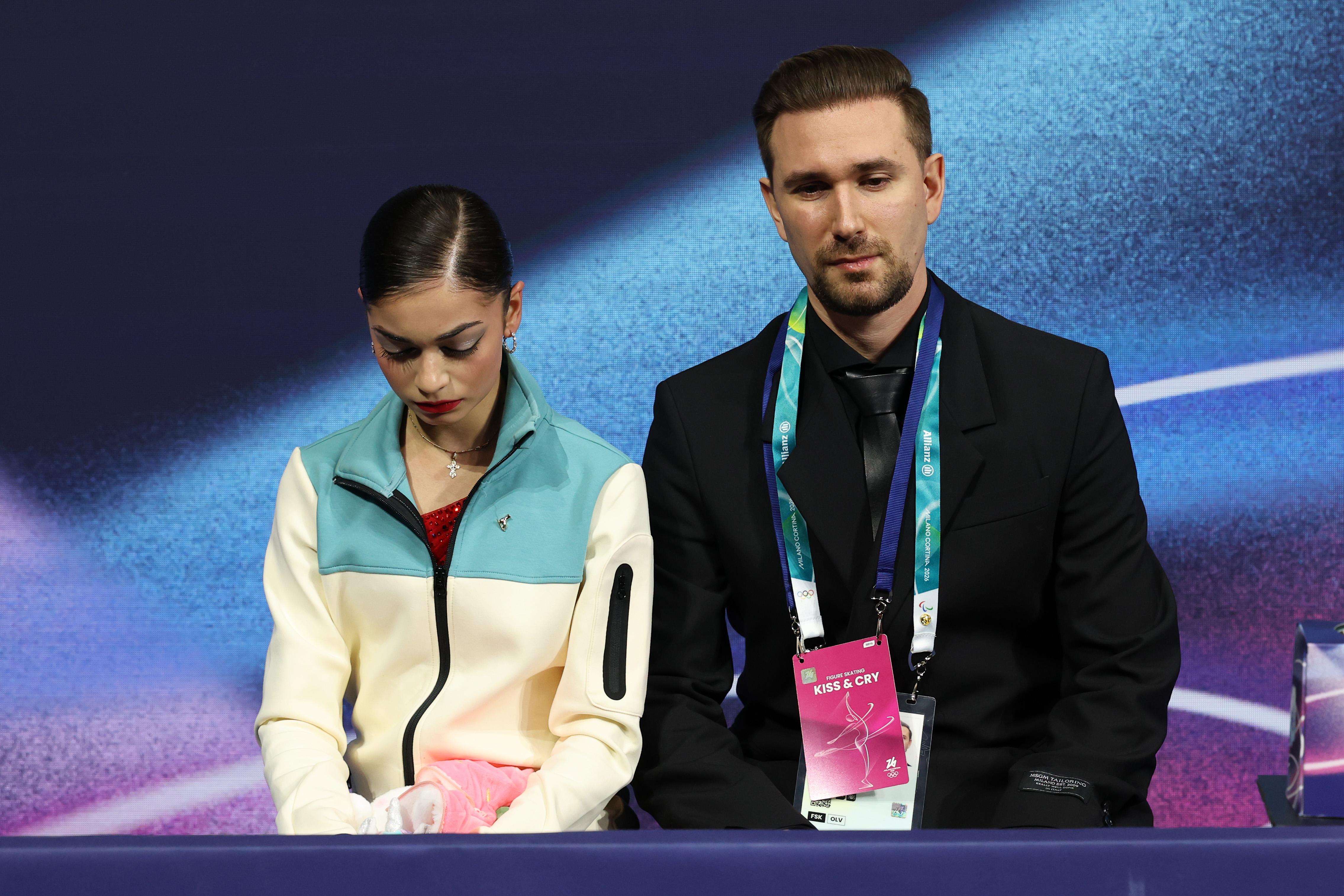MILAN, ITALY - FEBRUARY 19: Adeliia Petrosian of Team Individual Neutral Athlete reacts with her team in the Kiss and Cry zone after competing in Women's Single Skating - Free Skating on day thirteen of the Milano Cortina 2026 Winter Olympic games at Milano Ice Skating Arena on February 19, 2026 in Milan, Italy. (Photo by Matthew Stockman/Getty Images)