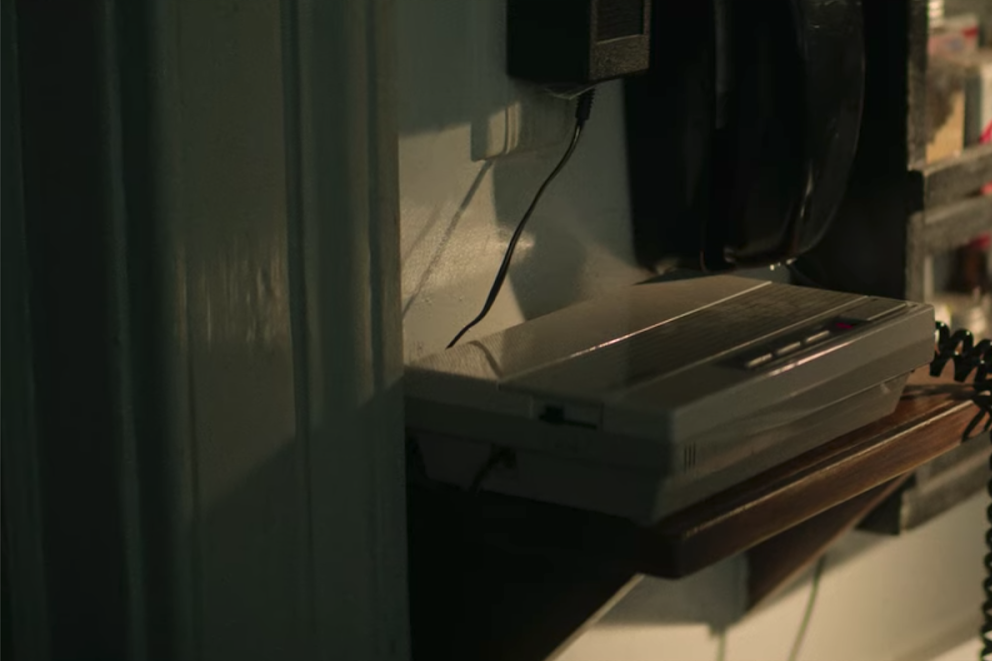 An answering machine sits on a ledge in an apartment entryway.