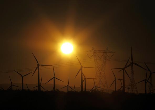 The sun rises behind windmills at a wind farm, February 9, 2011. 