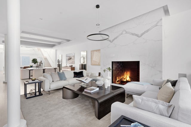 A very swanky living room with columns and a fireplace