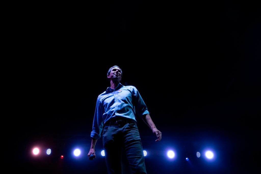 Beto O'Rourke, shot from below in hero/rock-star fashion with stage lights in the background.