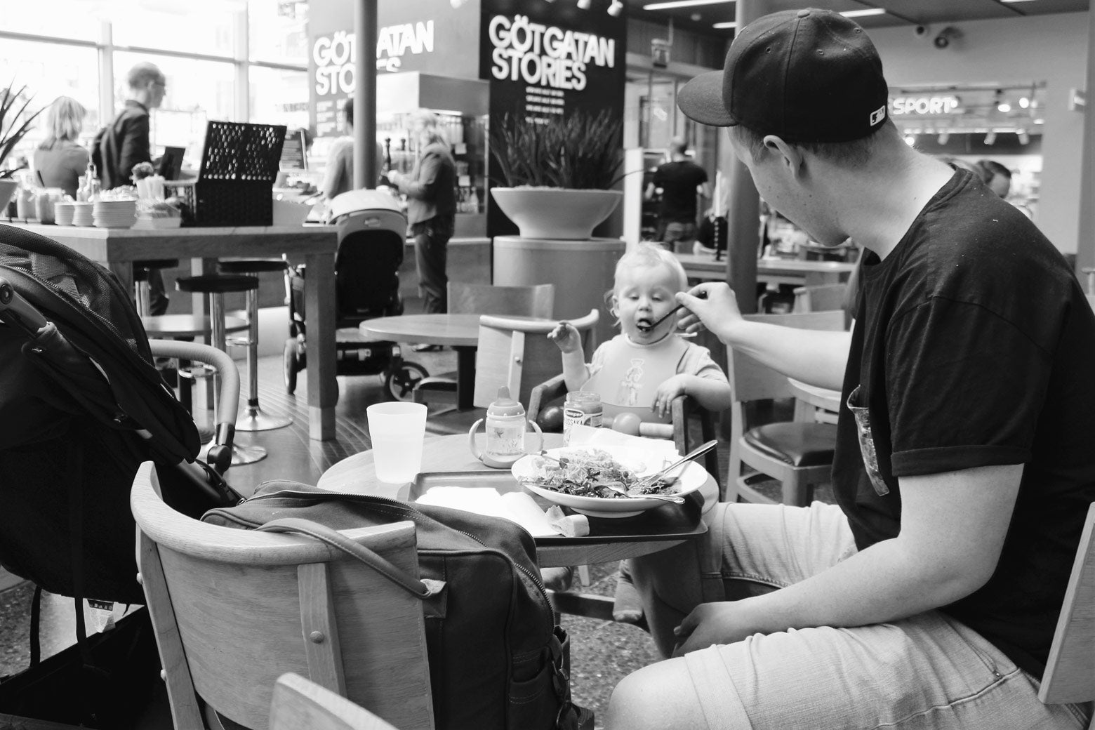 A father enjoying an afternoon lunch with his child at a shopping mall in Södermalm. 