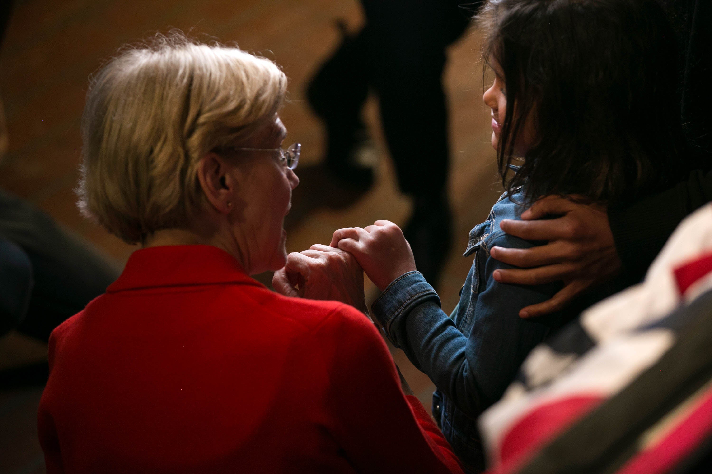 Elizabeth Warren crouches to speak with a child at Bogart's in Cincinnati on May 11.