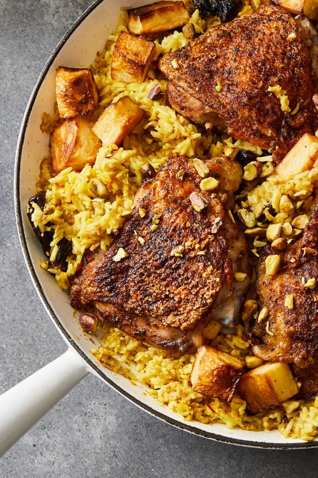 Garam masala chicken thighs with cubed potatoes and saffron rice in a skillet