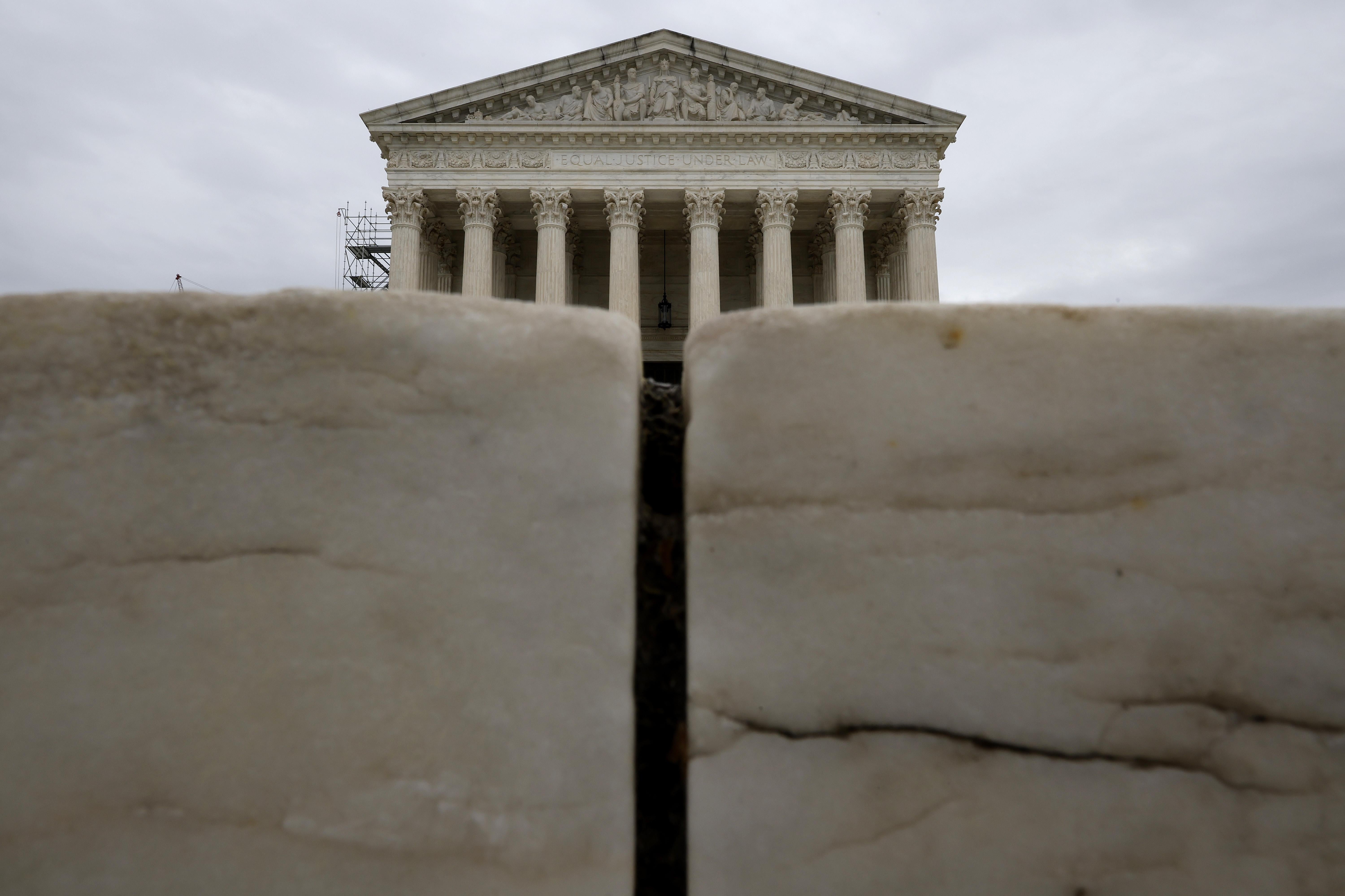 The U.S. Supreme Court rises above the marble steps leading to the court building. The building is mostly obscured.