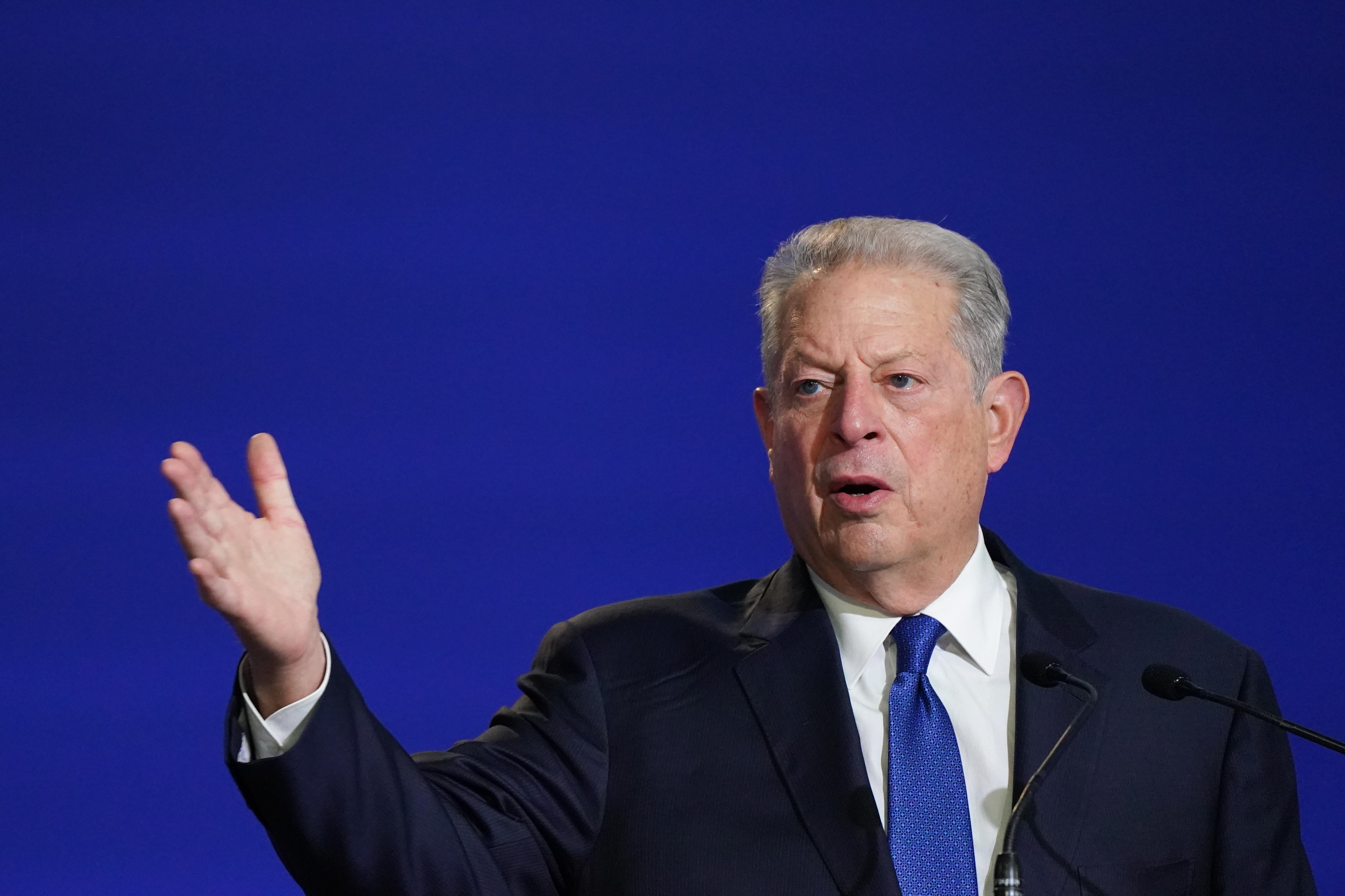 Al Gore speaking and raising his right hand