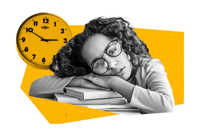A girl slumps over a book on her desk with a clock ticking behind her