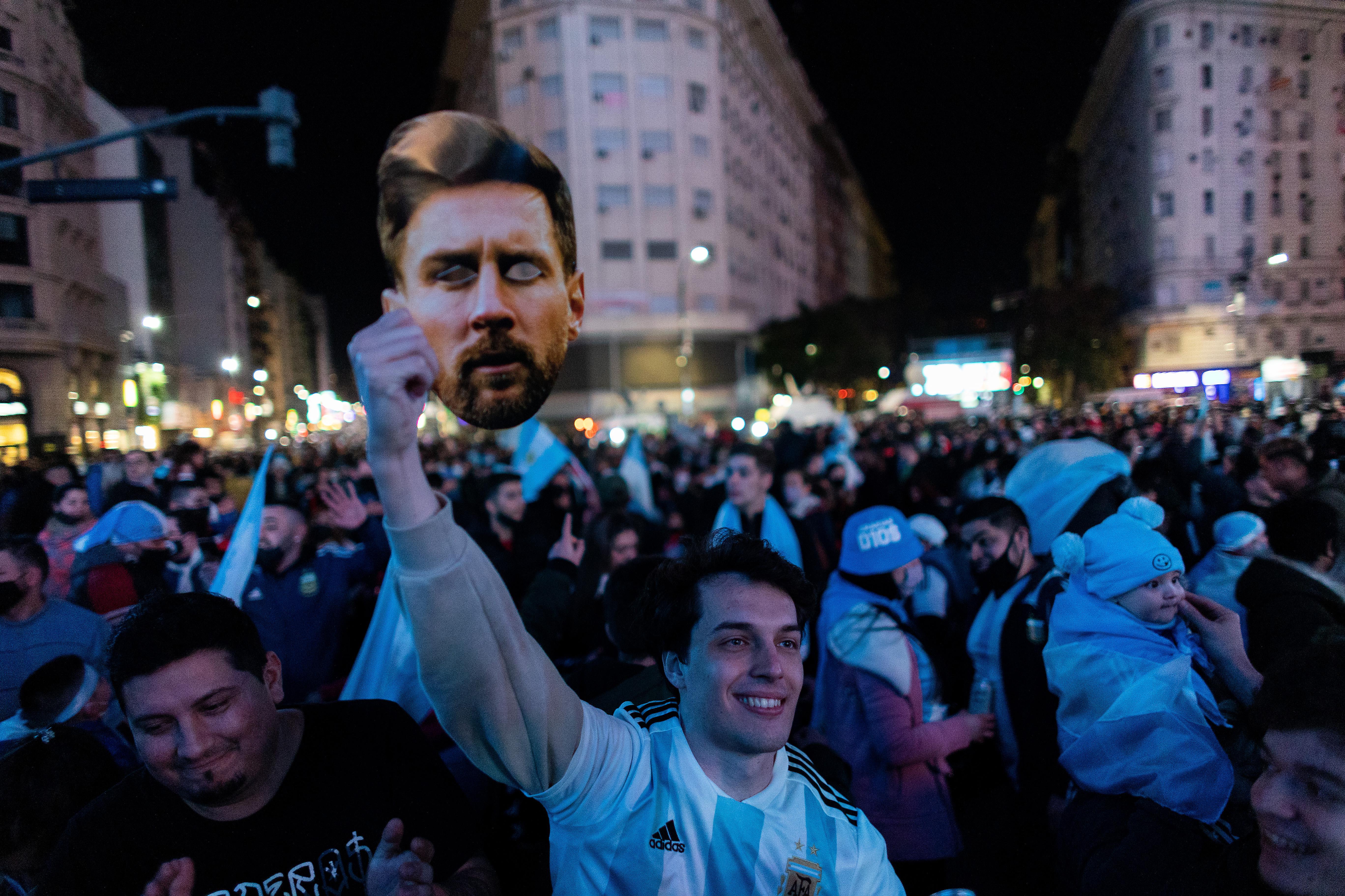 An Argentine fan holds a picture of Lionel Messi as fans gather to celebrate at the Obelisk after their team won the Copa America final against Brazil on July 10, 2021 in Buenos Aires, Argentina.