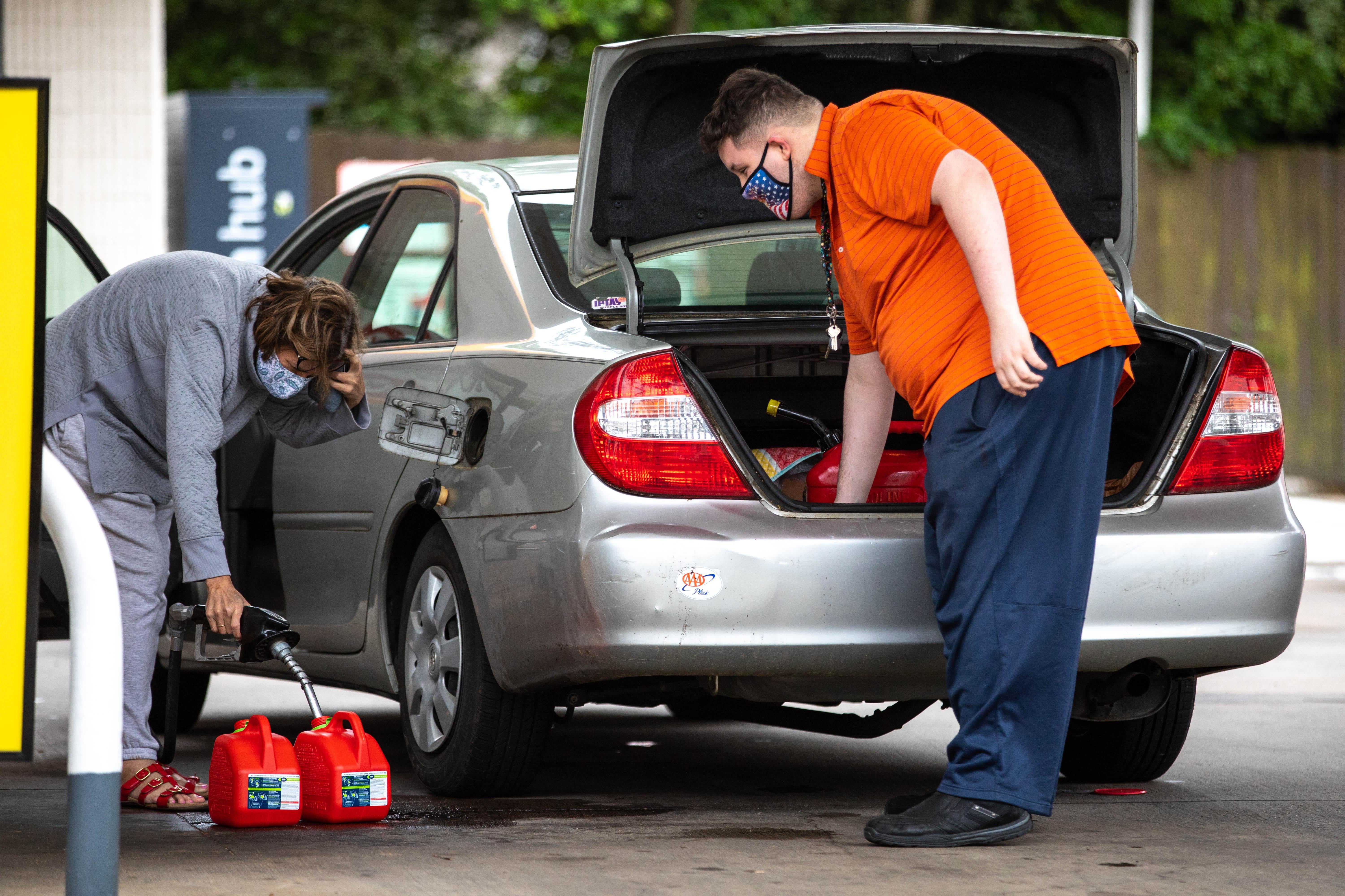 Motorists fill up gas cans at a Shell station in Charlotte, North Carolina on May 12, 2021. 