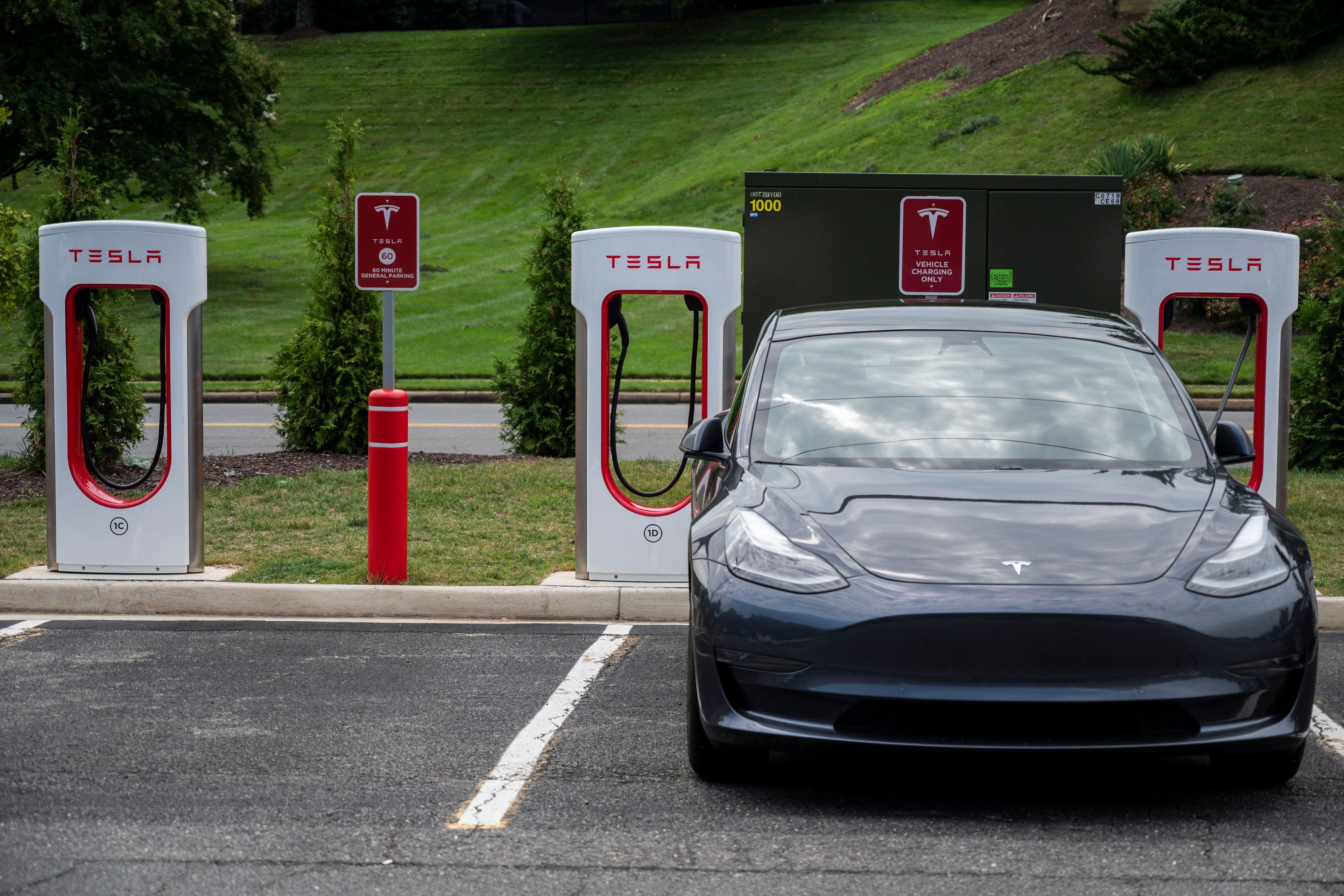 Cars charge at a Tesla super charging station. 