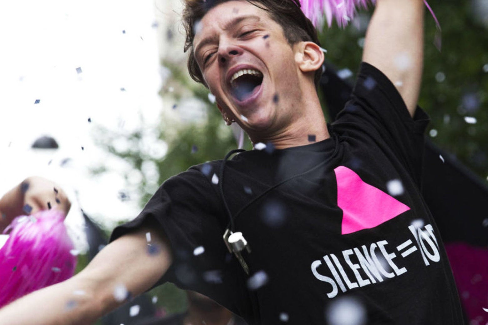 In a still from BPM (Beats per Minute), a character rejoices with pink pompoms during a parade.