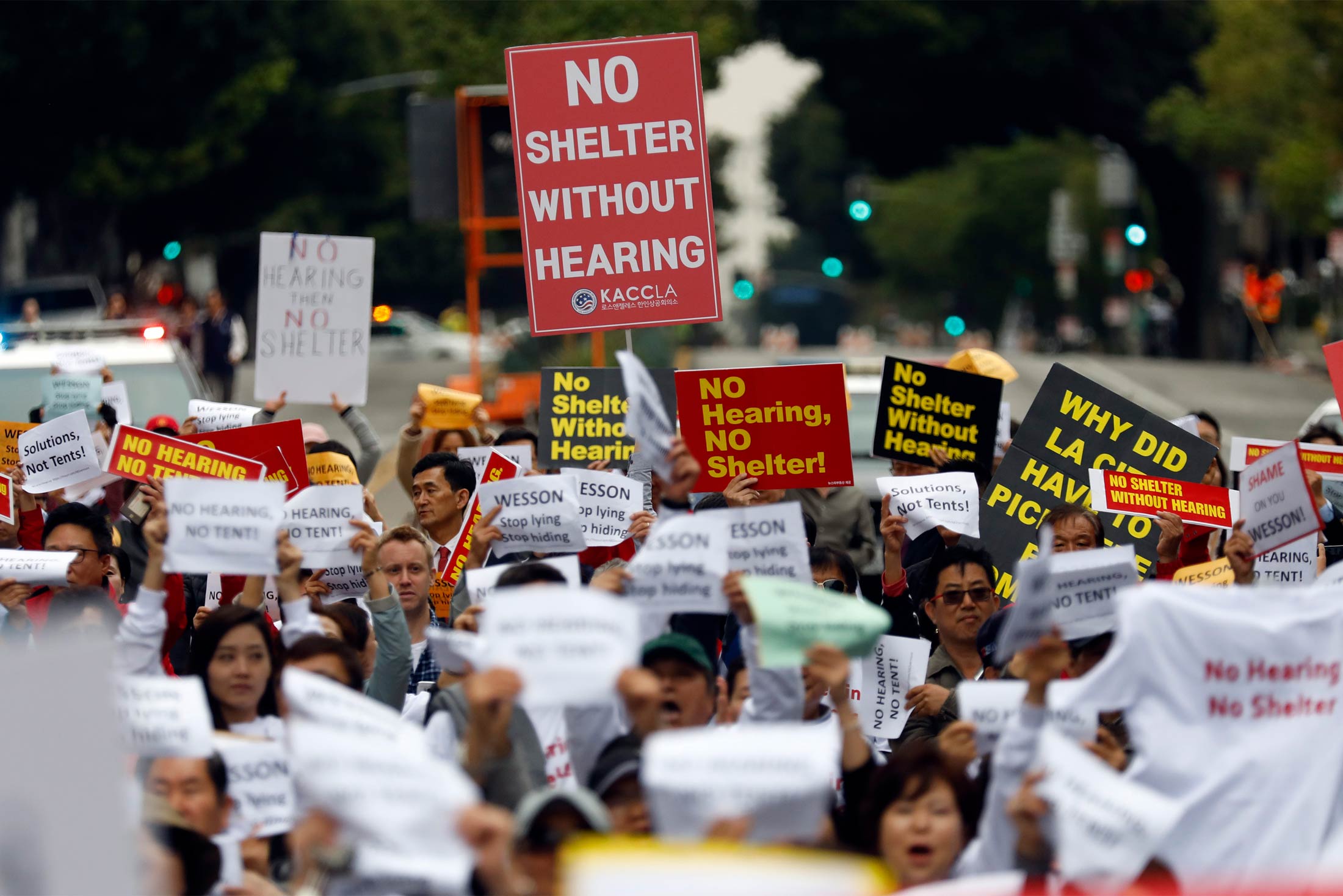 Protesters hold signs saying things like, "No shelter without hearing."