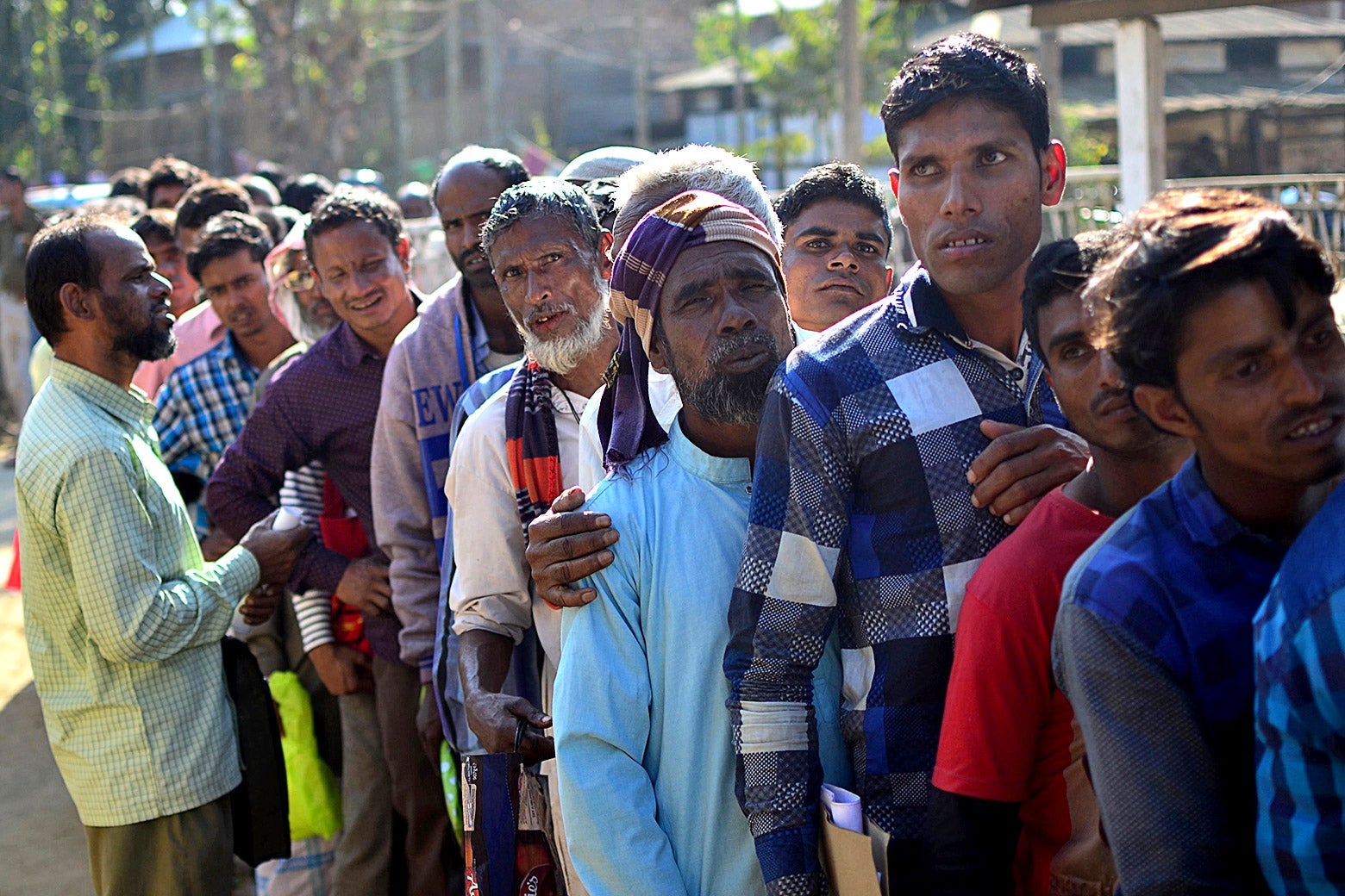 People stand in line to check their names on the first draft of the National Register of Citizens (NRC) at Gumi village of Kamrup district in the Indian state of Assam on Jan. 1, 2018.