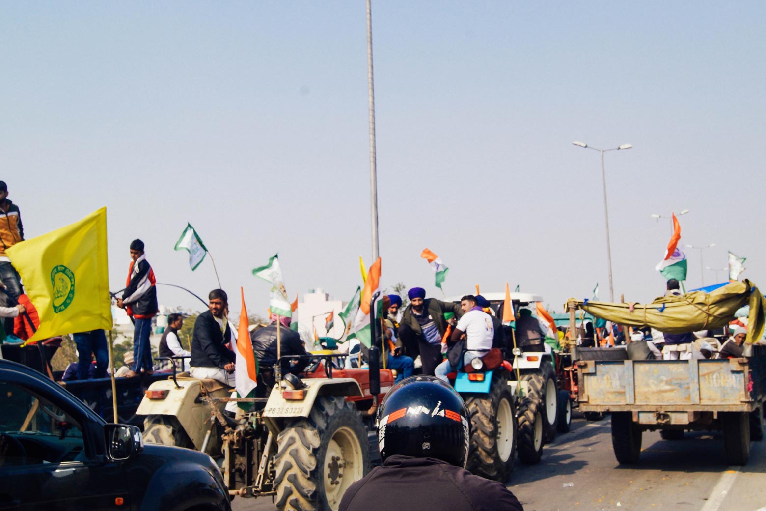 Protesters drive tractors down a highway.