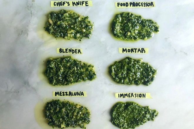 On a marble countertop, six globs of pesto, labeled "Chef's Knife," "Blender," "Mezzaluna," "Food Processor," "Mortar," and "Immersion."